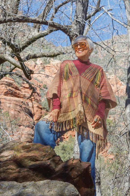 Poncho con textil 100% artesanal tejido en telar de pedal con deshuilados mediano en franjas en todo lo alto. De corte oversize con cuello en V y flecos en la parte inferior.