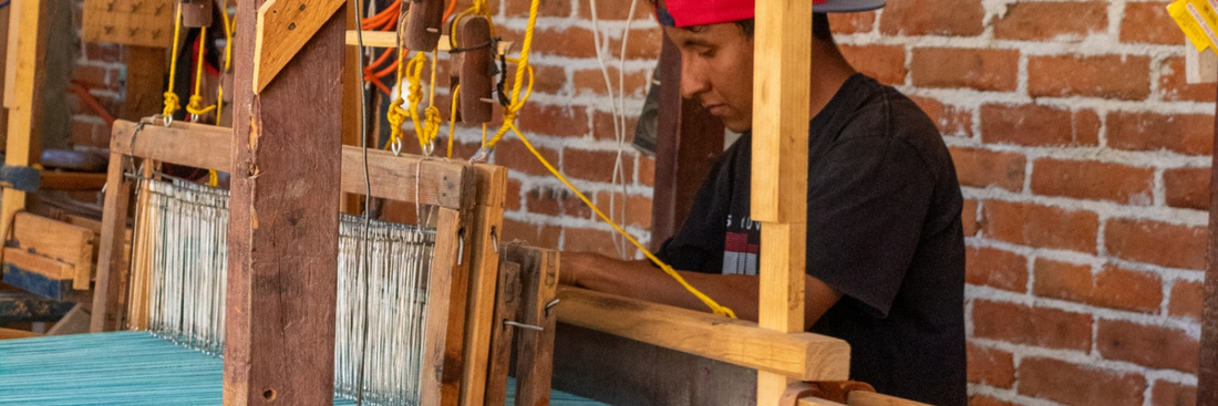 Artesano mexicano tejiendo un textil hecho a mano, en su telar de pedal 