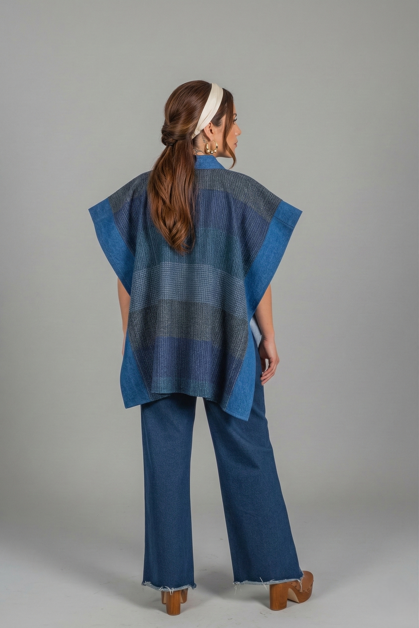 Chaleco de diseño original mexicano con textil artesanal tejido en telar de pedal y enmarcado con mezclilla de stock muerto. Bolsas al frente y cerrado parcialmente en los laterales. Visto de espalda.