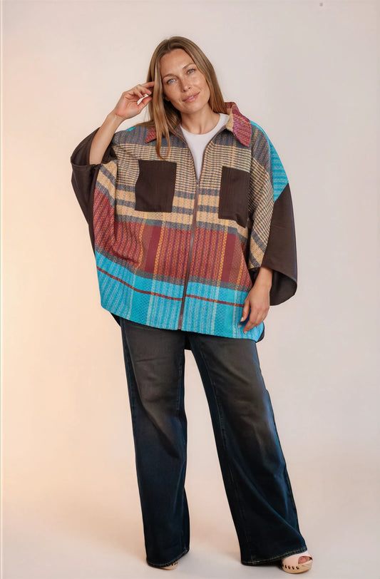 Poncho oversize unisex con cierre al frente y cuello camisero, con azul en la parte frontal inferior.