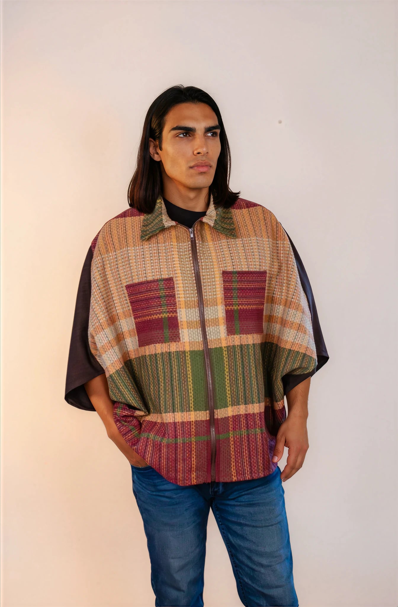 Poncho oversize unisex con cierre al frente y cuello camisero, con guinda y verde en la parte frontal inferior.