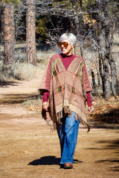 Poncho con textil 100% artesanal tejido en telar de pedal con deshuilados mediano en franjas en todo  lo alto. De corte oversize con cuello en V y flecos en la parte inferior.