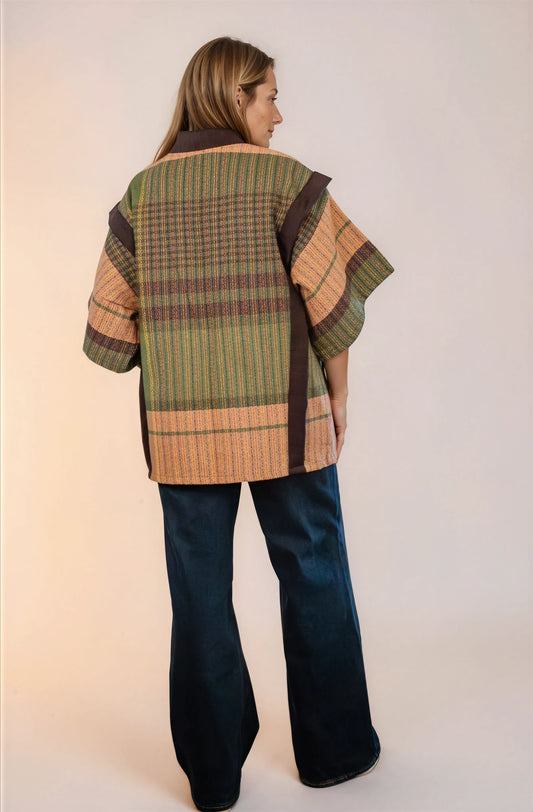 Saco laego abajo de la cadera, con mangas a los codos. Abierto del frente y con dos botones de estilo retro y bolsas en los laterales. Vista de espalda.